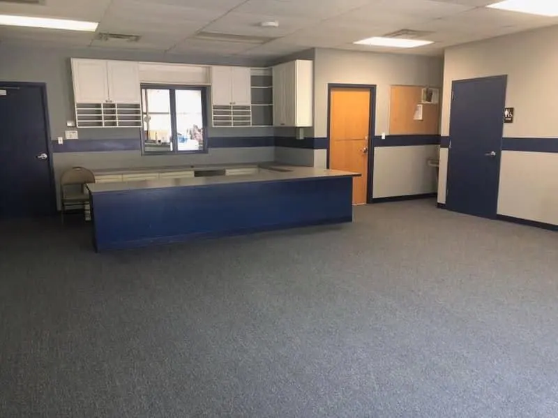 The same reception area before: worn gray commercial carpet
